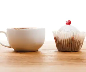 A delicious cappuccino and a cupcake
