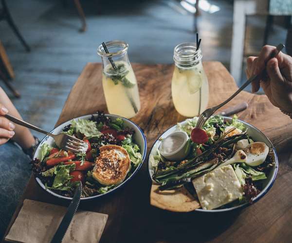 Two people each enjoying a fresh salad bowl