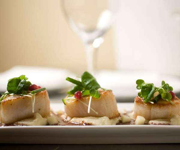 Three fresh scallops beautifully presented on a plate